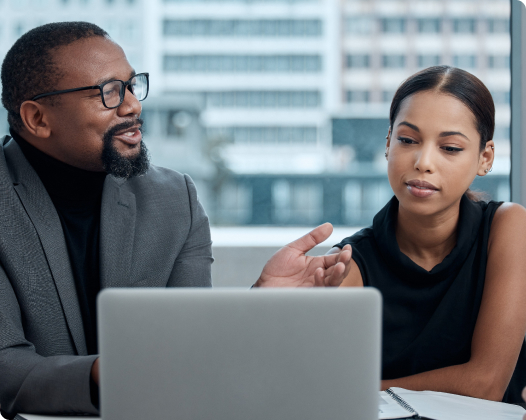 Two African American people looking at a laptop