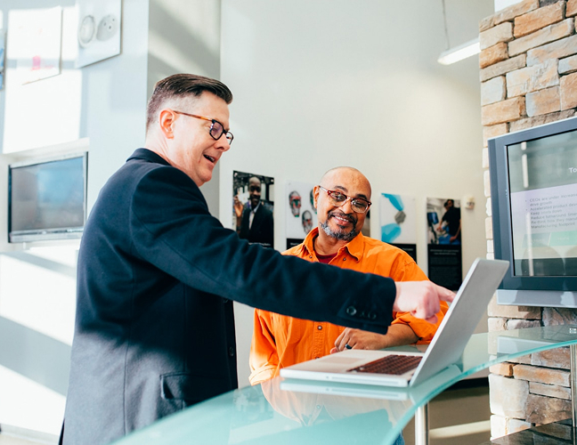 Two men staring at laptop