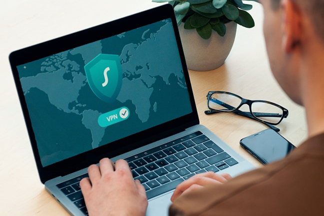 Over-the-shoulder shot of man looking at laptop