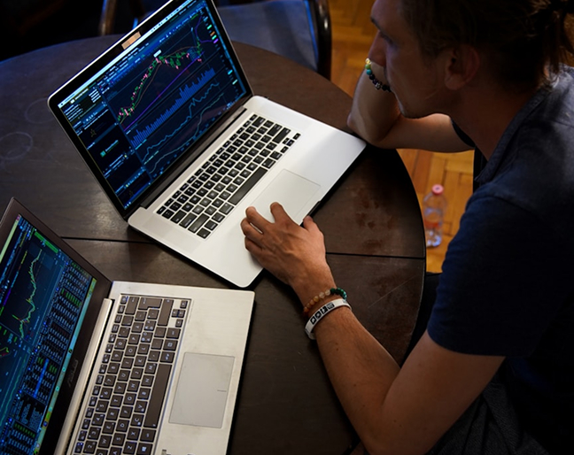 Man looking at two laptops