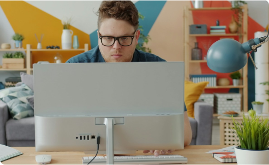 Man with glasses looking at laptop