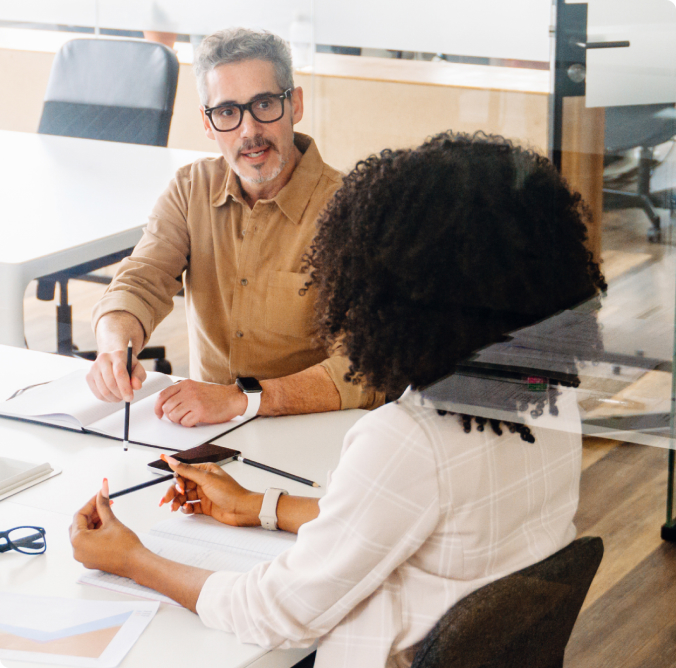 Two people at desk talking