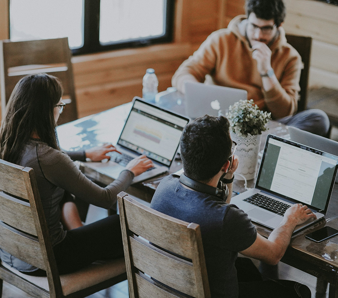 Three people looking at their own laptops
